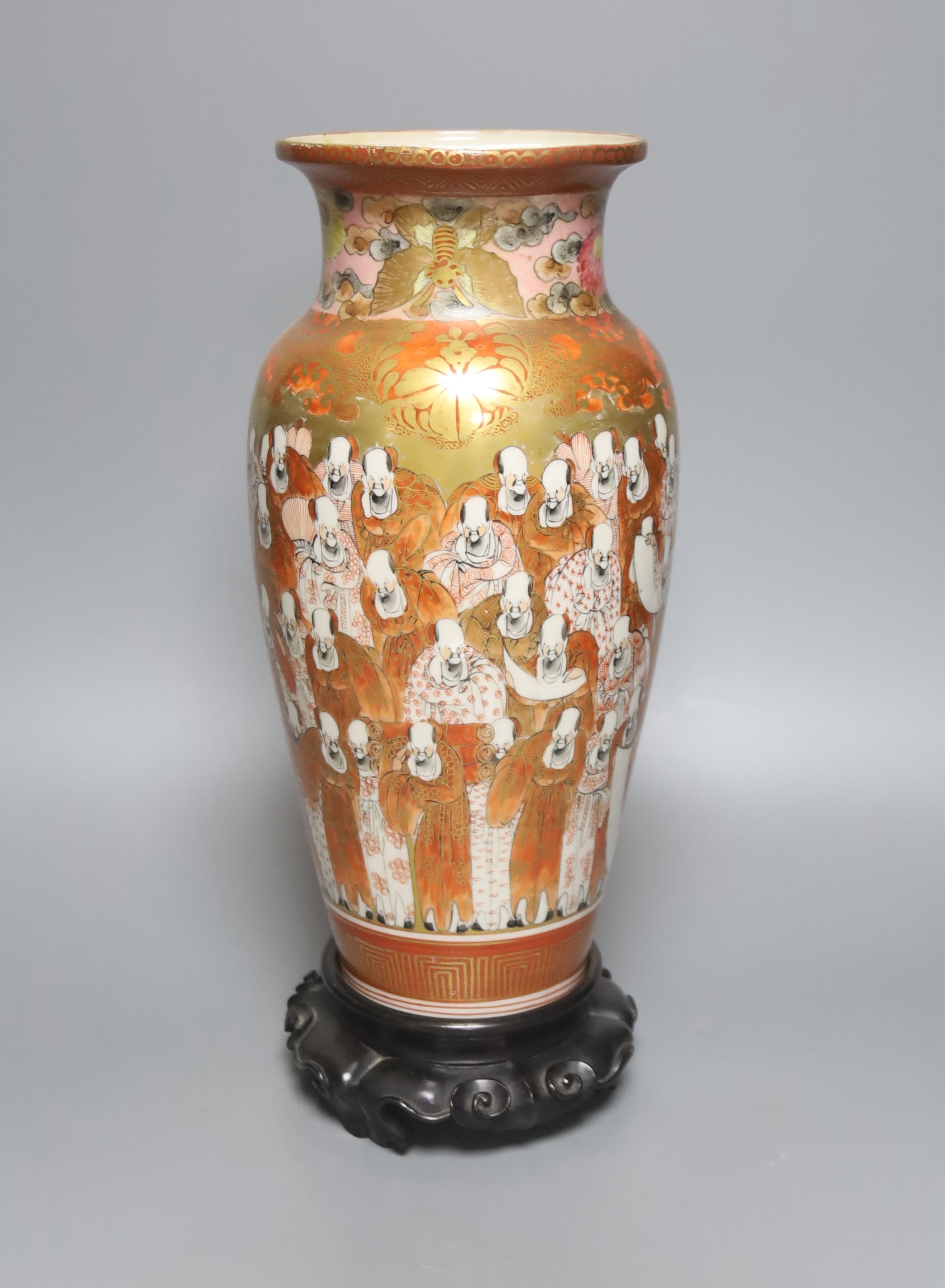 A tall Japanese Kutani porcelain vase, decorated with Rakan, 30cm, wood stand